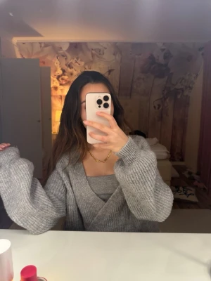 Grå omlott kofta i stickat material - Supermysig grå omlott kofta i stickat material med knyt. Jätteskönt material och sticks inte.