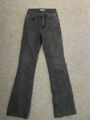 Grå bootcut jeans från Gina  - Snygga grå jeans från Perfect Jeans i klassisk bootcut-modell. Jeansen har hög midja och raka ben som går ut lite nedtill. Tillverkade i mjukt denimtyg som sitter skönt hela dagen. Perfekta till en avslappnad och trendig look.