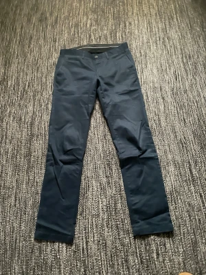 Mörkblå chinos med rak passform - Snygga mörkblå chinos med rak passform och klassisk design. Byxorna har knapp och dragkedja framtill samt bälteshällor i midjan. Tillverkade i ett mjukt och bekvämt bomullsmaterial som passar perfekt till en avslappnad stil.Var inte rädd för att skicka om du har någon fråga eller vill ha fler bilder!
