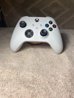 Vit Xbox Series X/S handkontroll - Säljer en vit Xbox Series X/S handkontroll med klassisk design, svarta styrspakar och färgade knappar. Tillverkad i slitstark plast och har en skön ergonomisk form som passar perfekt för gaming. Passar både till Xbox och PC via Bluetooth.