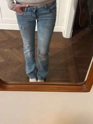 Boutcut Jeans med slitingar, Lee. - Säljer mina sljusblå Jeans ifrån Lee. Jag säljer dom då dom inte kommer till användning. Dom är låga i midjan och boutcut nertill. Dom är i storlek 26 i midjan och 33 i längden, men jag skulle säga att dom är ganska strechiga. Hör av er vid frågor eller om ni önskar fler bilder m.m,  Pris kan diskuteras!!🩷🩷🩷Midjemåttet är 66 cm