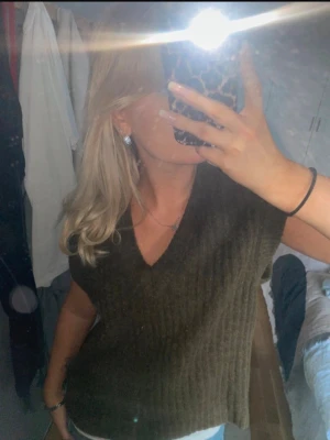 Brun stickad väst - Cool brun stickad väst från NORR med v-ringning och ribbad struktur. Västen är ärmlös och har en avslappnad passform, perfekt att styla över en skjorta eller t-shirt. Materialet känns mjukt och ger en trendig lager-på-lager-look. Lite oversized och använd fåtal gånger!🤎köpt för 679kr