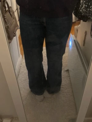 Mörkblå bootcut jeans - Snygga mörkblå jeans med bootcut passform och klassisk femficksdesign. Jeansen har en rak och något utsvängd benform som ger en avslappnad vibe. Perfekta för dig som gillar en tidlös och trendig look.