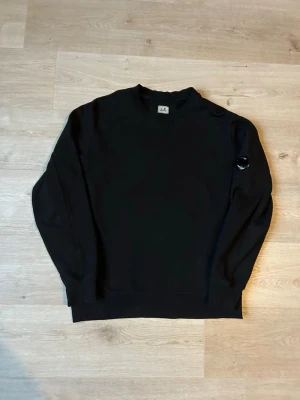 Svart CP Company Tröja Crewneck  - Fin CP Company tröja i svart färg. Tröjan är i mycket bra skick och sparsamt använd. |  Äkta som allt annat jag säljer! ✅|  Storlek: L | Skick: Mycket Bra Skick | Färg: svart | Märke: C.P Company | Modell:  crewneck, tröja |  Mått: | Längd: 70 cm | Bröstvidd: 56 cm |  Hör gärna av dig vid frågor så svarar jag så fort jag kan! 🙂|  