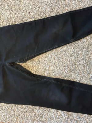 Svarta skinny jeans i stretch - Snygga svarta skinny jeans med klassisk femficksdesign och dragkedjegylf. Jeansen har en tight passform och är tillverkade i stretchigt material för extra komfort. Perfekta för dig som gillar en slimmad siluett och enkel stil.