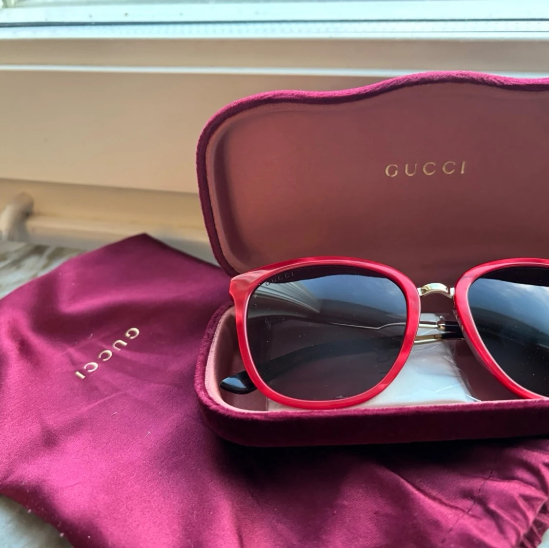 Röda Gucci solglasögon med gulddetaljer