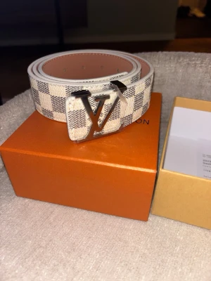 L bälte beige rutigt - Beiget bälte, rutigt mönster, fantastisk kvalité, aldrig använd, Storlek 44, 110cm