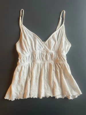 Vitt babydoll linne - Vitt linne i storlek S (passar xs-m) från Gina Tricot. Passformen är mycket fin i babydoll stil och omlott upptill 💞 materialet är lite stretchigt och formar sig efter kroppen :) Den ser lite krämvit ut på bilden men är egentligen vit. Köpt några månader sedan och endast använd ett fåtal gånger! 