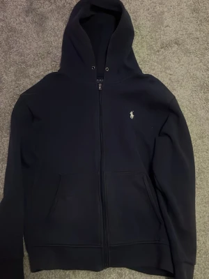 Ralph Lauren zip hoodie - Skön Ralph Lauren zip hoodie som saknar snören,   den är lite solblek då den har en lite mer lila aktig färg, storlek L och hör gärna av er om ni har några funderingar.