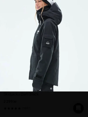 Svart skidjacka från Dope - Säljer en svart skidjacka från Dope med huva och flera praktiska fickor. Jackan har vita detaljer på snören och knappar, samt logga på bröstet och ärmen. Perfekt för dig som älskar vintersport och vill ha en stilren look i backen. Nypris ligger på 2 299kr. 
