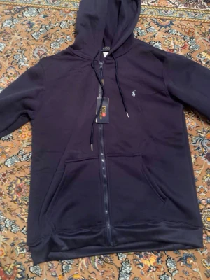 Polo Ralph Lauren Zip Hoodie - Polo Ralph Lauren zip hoodie Mörkblå hoodie med dragkedja och vit broderad logga. Bra passform och skön kvalitet.  Skick: 10/10 Märke: Polo Ralph Lauren