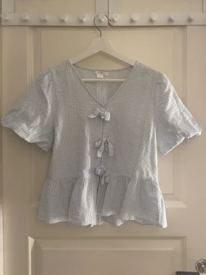 Blå vit randig blus med volang, rosetter och puffärmar - Säljer den här söta blå vit radiga blusen från Gina Tricot med rosetter, en volang och puffiga ärmar💞