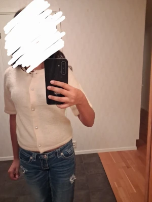 Gul kofta med pärlknappar - Säljer en söt gul kofta med korta ärmar och pärlknappar framtill. Koftan har en mjuk och fluffig känsla, är lite croppad och passar perfekt till jeans. Andvänd en gång!