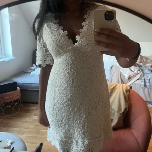 Vit spetsklänning med v-ringning - Säljer en superfin vit kortklänning med spetsdetaljer och v-ringad hals och bak. Perfekt för bland annat student eller skolavslutning! Pris går att diskutera!🤍