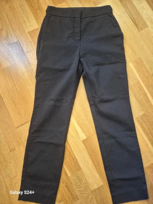 Svarta kostymbyxor från Zara, S - Svarta kostymbyxor från Zara i storlek S. Klassisk rak modell med fickor fram och bak, elastisk midja och stilren look. Perfekt för dig som gillar en clean och enkel stil. Materialet är mjukt och bekvämt, passar till många olika outfits.
