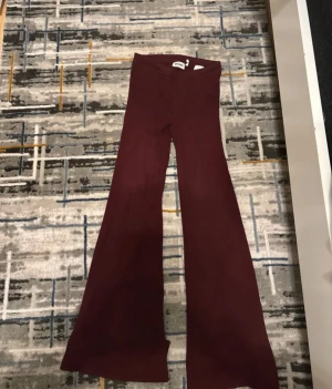 Mörkröda ribbade bootcut byxor - Snygga vinröda ribbade byxor från weekday med  bootcut . Byxorna är stretchiga och har en mjuk, stickad känsla som gör dem riktigt bekväma. Perfekta för dig som gillar en trendig och mjuka sköna mjukis leggings 