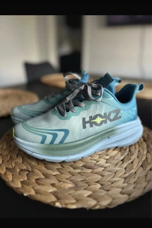 Turkosa HOKZ sneakers strl 41 - Säljer ett par snygga turkosa sneakers från HOKZ i storlek 41. Skorna har en sportig design med grå snörning, ljusblå och gröna detaljer samt en tjock, platt sula. Knappt använda och i mycket bra skick💞