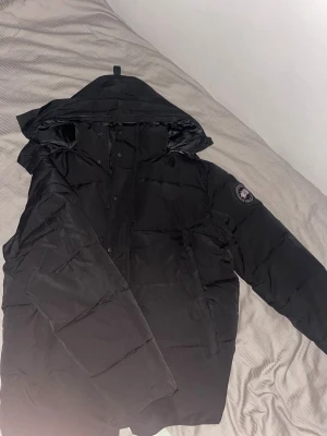 Canada goose Wyndham - Säljer en Canada Goose Wyndham Parka Black Label, helt ny och aldrig använd. Endast provad snabbt hemma. Ett av de mest eftertraktade plaggen i Black Label-kollektionen – stilren, lyxig och extremt varm!  ✔ Modell: Canada Goose Wyndham Parka – Black Label ✔ Färg: Black Label (svart detaljer, exklusiv look) ✔ Storlek: Xs passar S ✔ Skick: Helt ny, oanvänd, utan minsta användningsspår