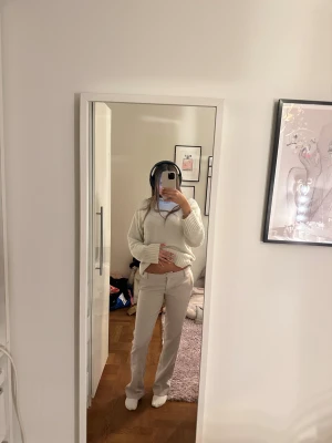 Beiga kostymbyxor med raka ben - Säljer ett par stilrena beiga kostymbyxor med låg midja och raka ben. Byxorna har klassiska fickor fram och passpoalfickor bak. Perfekta för en clean och snygg look. Materialet känns mjukt och följsamt, och färgen är ljusbeige som passar till det mesta.