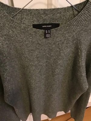 Grå stickad tröja Vero Moda XS - Mysig grå stickad tröja från Vero Moda i storlek XS. Tröjan har rund halsringning, ribbade muddar och lång ärm. Perfekt för kyliga dagar och enkel att matcha med jeans eller kjol. Snygg basic som funkar till allt.