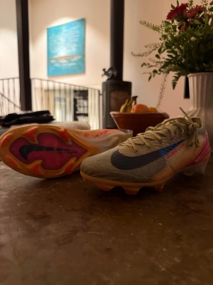 Nike Air Zoom Mercurial fotbollsskor - Säljer ett par Nike Air Zoom Mercurial elit fg [vanligt gräs] fotbollsskor i gult med svarta och röda detaljer. Skorna har snörning, platt sula med dobbar och en stor svart swoosh på sidan. Ovandelen är i syntetmaterial och baksidan har en digital-inspirerad grafik i rött och vitt. PRIS KAN DISKUTERAS!