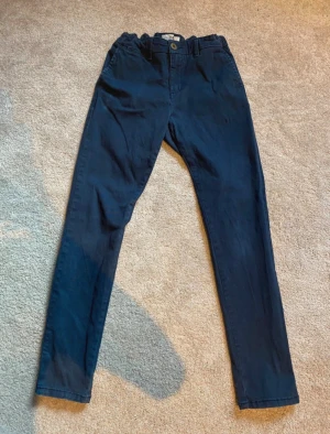 Mörkblå chinos från Hampton Republic - Snygga mörkblå chinos från Hampton Republic med klassisk rak passform och normal midja. Byxorna har sidfickor, knapp och dragkedja fram samt bälteshällor. Perfekta för en stilren look och tillverkade i mjukt bomullsmaterial.