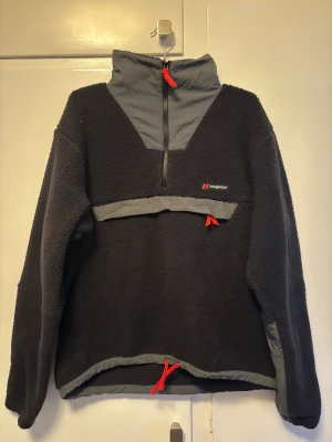 Svart fleecejacka från Berghaus - Oanvänd fleece från Berghaus. Ficka på magen och resår nertill.