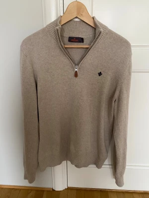 Beige stickad tröja med half zip Morris - Snygg beige stickad tröja från Morris med half zip och ribbad krage. Priset kan diskuteras. Fraktas inom 1 dag.