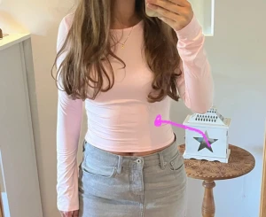 Ljusrosa långärmad topp - Supersnygg ljusrosa långärmad topp med rund hals och tight passform. Materialet är mjukt och stretchigt, troligen polyester eller bomull. Enkel och clean design utan mönster eller detaljer, perfekt att styla med jeans eller kjol.(finns mindre fläckar på armen)