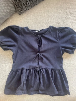 Svart blus med knyt och volang - Marin blå blus med rosetter