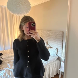 Svart kofta med pärlknappar - Säljer en svart kofta med rund hals och snygga pärlknappar framtill, från missäy storlek s-m, använt fåtal gånger.