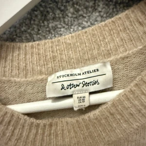 Beige stickad tröja & Other Stories - Beige oversized stickad tröja från & Other Stories. Den är väldigt stor i storlek så skulle säga att den är som en s/m i storlek!!☺️