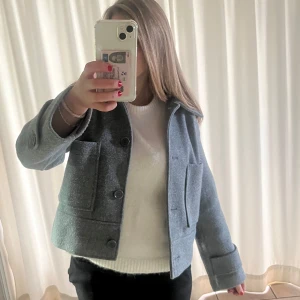 Grå kappa från Kappahl XS - Säljer en grå kappa från Kappahl i storlek XS. Kappan har stora fickor framtill, klassisk krage och knäppning med tre knappar. Perfekt för lager-på-lager och har en clean, minimalistisk vibe.