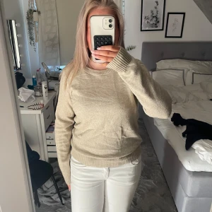Beige stickad tröja från VILA - Snygg beige stickad tröja från VILA med rund halsringning och ribbade muddar vid ärmslut och nederkant. Perfekt basic till garderoben, enkel att matcha och supermjuk mot huden.