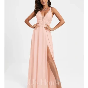 Ljusrosa långklänning med spetsdetaljer - Supersnygg ljusrosa långklänning från JJ's House med spets upptill, djup v-ringning och öppen rygg med snörning. Klänningen har slits framtill och tunna axelband. Perfekt för bal eller andra tillfällen. Skriv för mått!