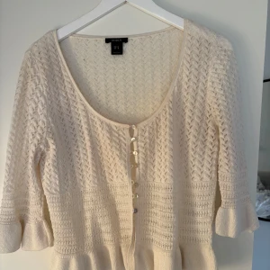 Vit kofta från Lindex med volangärm - Supersöt vit kofta från Lindex med trekvartsärm och volangdetalj vid ärmslut. Storlek M men sitter perfekt på mig som vanligtvis bär xs-s ❤️ koftan funkar perfekt som bara en topp alternativt en kofta över ett annat plagg !