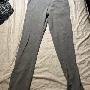 Grå kostymbyxor Jack & Jones Slim - Snygga grå kostymbyxor från Jack & Jones i modellen Slim/Marco. Byxorna har en slim passform och raka ben, perfekta för en clean och stilren look. Tillverkade i ett mjukt material som känns bekvämt hela dagen.