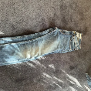Blå jeans från Tiger of Sweden - Snygga blå jeans från Tiger of Sweden. Unik tvätt. W 30 L 32. Slitning på bakfick annars mycket gott skick knappt använda. Slim/straight fit.