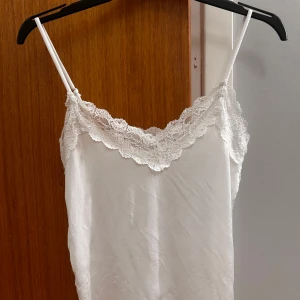 Vit linne med spetskant - Säljer ett vitt linne med tunna axelband och vacker spetskant längs urringningen. Super skön att sova i eller bara ha hemma😊