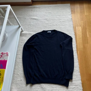 Mörkblå kashmirtröja Made in Italy - Säljer en klassisk mörkblå rundhalsad tröja i 100% kashmir från Cashmere, tillverkad i Italien. Tröjan har lång ärm och ribbade muddar vid ärmslut och nederkant. Perfekt för dig som gillar lyxigt mjuka material och stilren look.