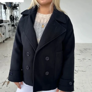 Svart kappa design by si - Svart kappa från design by si som är perfekt nu för höst och vinter! Storlek XS/S. 