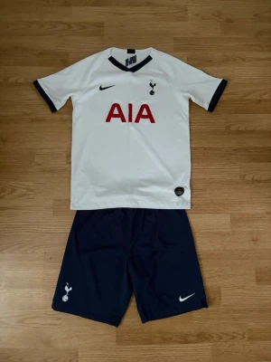 Nike Tottenham Hotspur FC Home Kit 19/20 för barn - Säljer denna då den inte längre används  Märke - Nike Lag - Tottenham Hotspur  Storlek - 158-170cm (XL)  Tröja Längd - 65cm Armhåla till armhåla - 46cm Ärmlängd - 14cm  Shorts Midjemått - 35cm Innerbenslängd - 20cm  Pris går att diskuteras