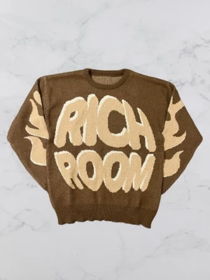 Brun richroom stickad tröja - Cool brun stickad tröja med stora beige bokstäver 'RICH ROOM' på framsidan och beige flames på ärmarna. Rund halsringning och ribbade muddar. Perfekt för dig som vill sticka ut med en unik och trendig look.