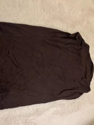 Svart basic t-shirt med rund hals - En enkel svart t-shirt med rund hals och korta ärmar. Perfekt att matcha med jeans eller shorts för en clean och stilren look. T-shirten har en klassisk passform och är tillverkad i mjukt material.