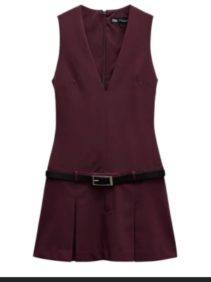 Vinröd kort klänning från Zara - Vinröd ärmlös klänning från Zara med djup v-ringning och svart bälte i midjan. Supersnyg!! Och aldrig använd