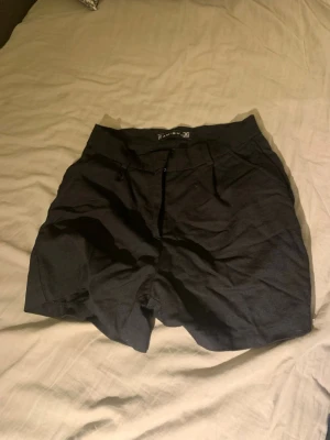 Svarta shorts från Amisu med dragkedja - Svarta shorts från Amisu med klassisk passform. De har dragkedja och knapp framtill samt hällor för skärp. Perfekta för sommaren och enkla att matcha med olika outfits. ( Kostymbyxor fast i shorts) 