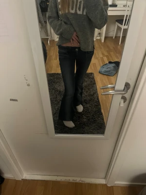 Bootcut jeans med låg midja - Säljer ett par mörkblå bootcut jeans med snygg slitning och låg midja. Jeansen har klassiska, dragkedja och knapp framtill. Materialet är mjukt denim i bomull med lite stretch för skön passform. Pris kan diskuteras 🩷🩷