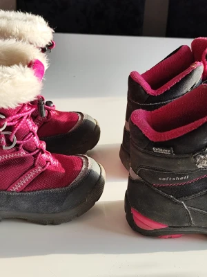 Fyra par rosa och svarta barnskor24/25 - Säljer fyra par barnskor: ett par fodrade vinterkängor från Gulliver i rosa och svart med snörning och fuskpäls, ett par svarta och rosa sneakers med snörning, samt ett par rosa gummistövlar från Nordic. Perfekt för olika väder och aktiviteter.