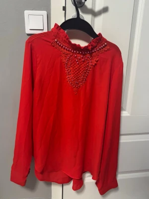Röd topp med pärl detaljer köpt utomlands  - Snygg röd topp köpt utomlands med röda pärtdetaljer som ger en unik look