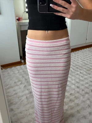 Rosa och vit randig långkjol - Säljer en långkjol med rosa och vita ränder i ett stickat material. Kjolen har en rak passform och är perfekt för dig som gillar en söt och trendig stil. Finns en matchande topp på mitt konto ☺️
